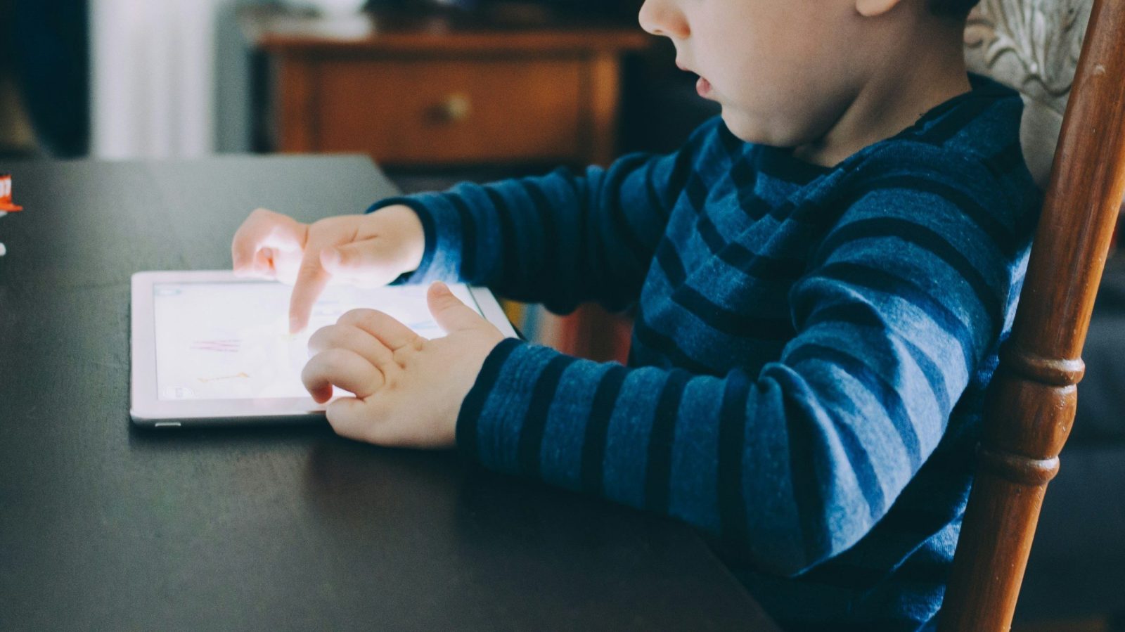 enfant assis qui manipule une tablette