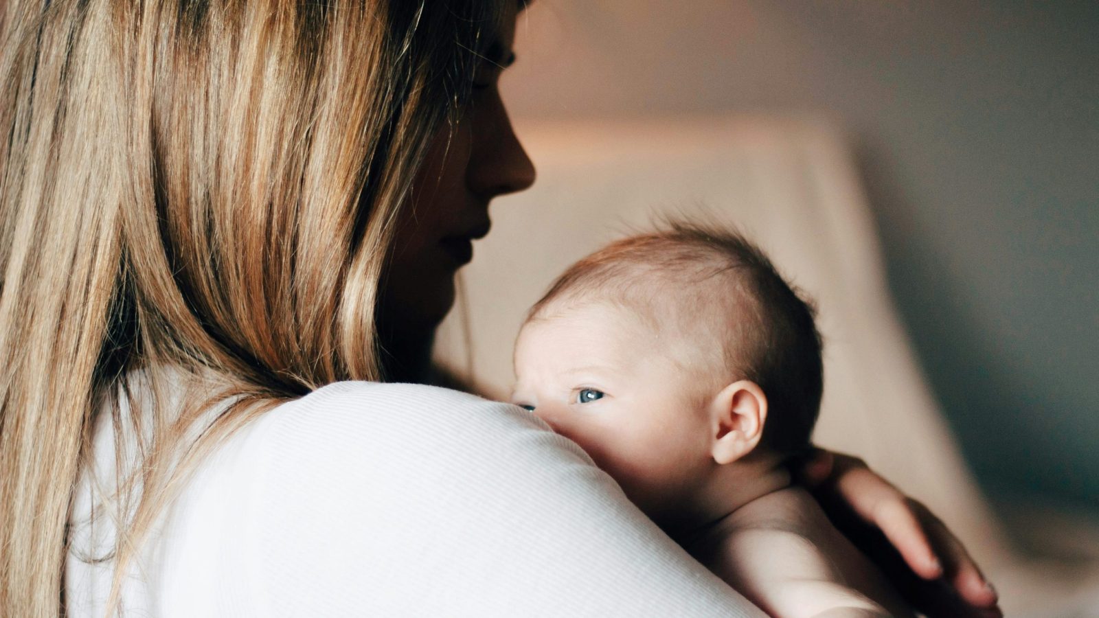 bébé dans les bras de maman qui regarde par-dessus son épaule